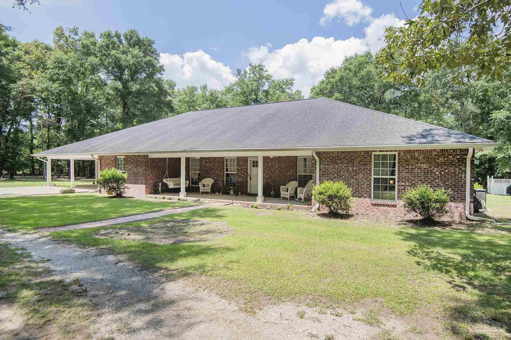 8501 Highway 97 Walnut Hill, FL 32568 - Photo 1 of 55 a front view of a house with a garden and porch