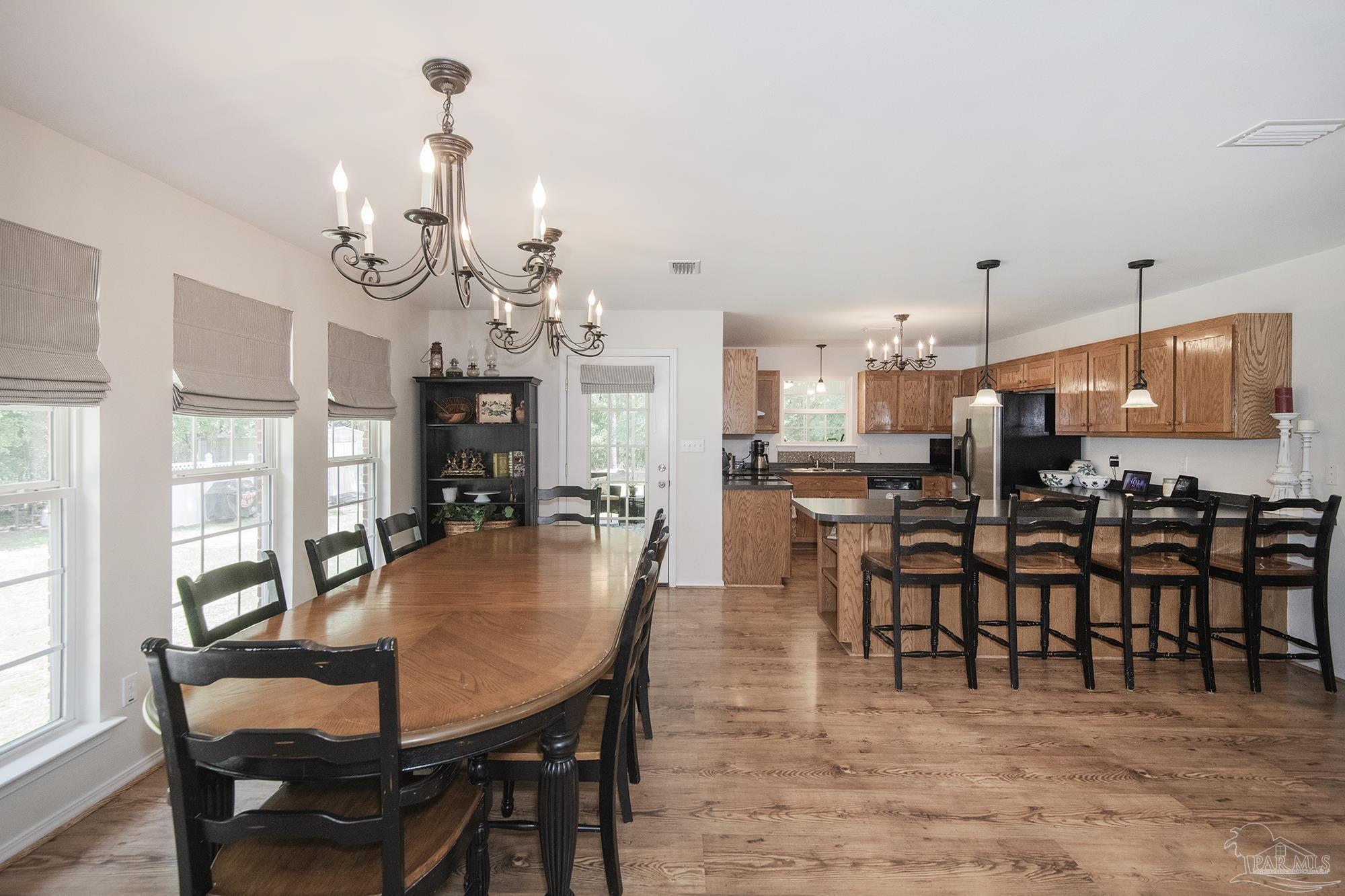 8501 Highway 97 Walnut Hill, FL 32568 - Photo 16 of 55 a dining room with furniture a chandelier and kitchen view