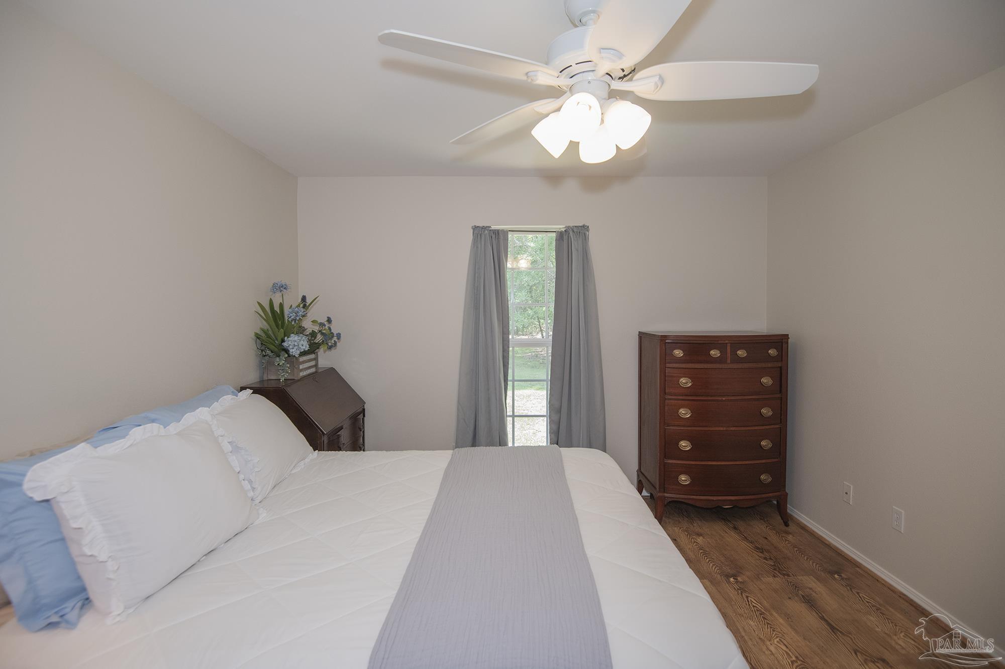 8501 Highway 97 Walnut Hill, FL 32568 - Photo 20 of 55 a bedroom with a bed and a chandelier
