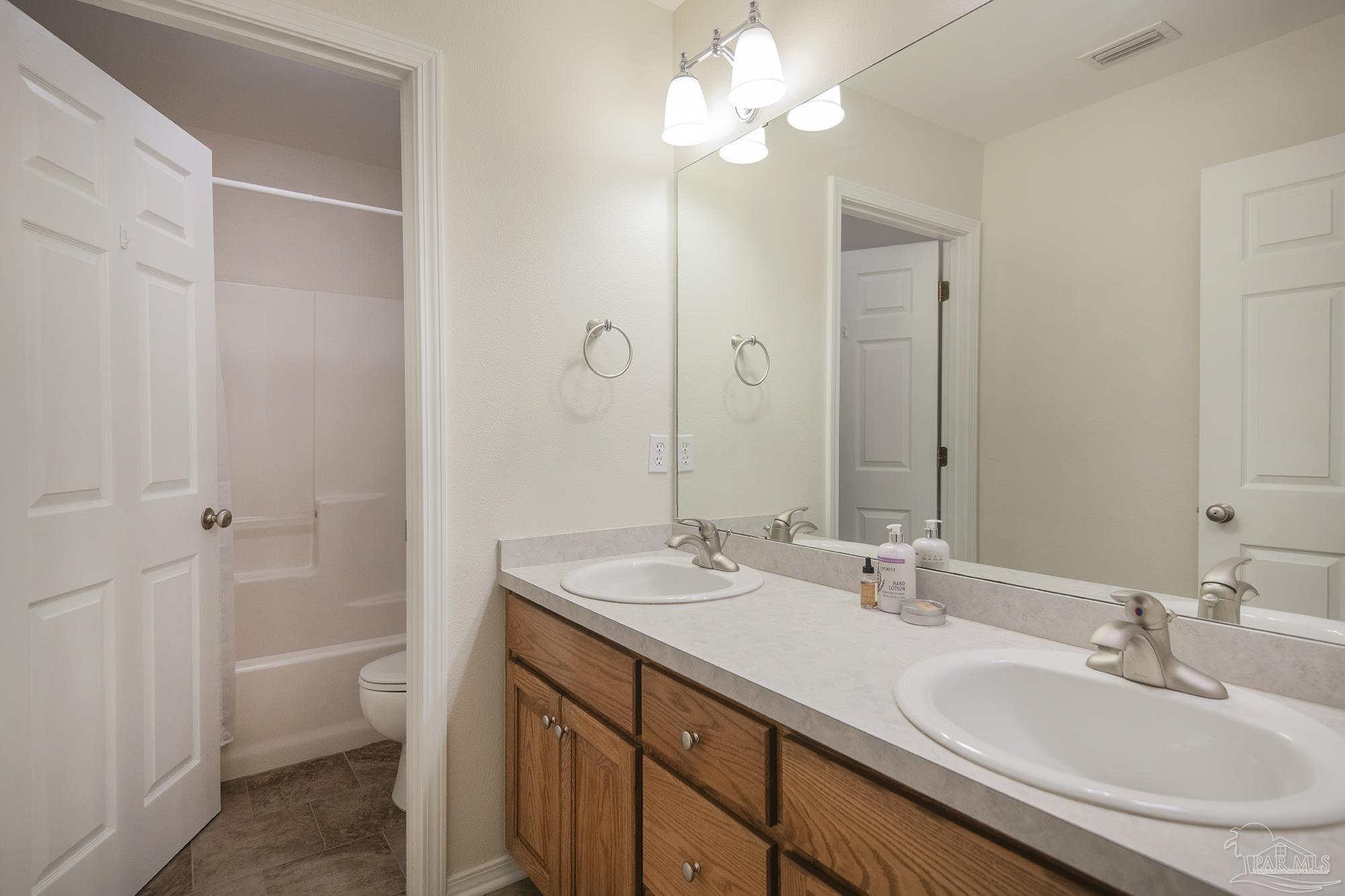 8501 Highway 97 Walnut Hill, FL 32568 - Photo 33 of 55 a bathroom with a sink a toilet and a mirror