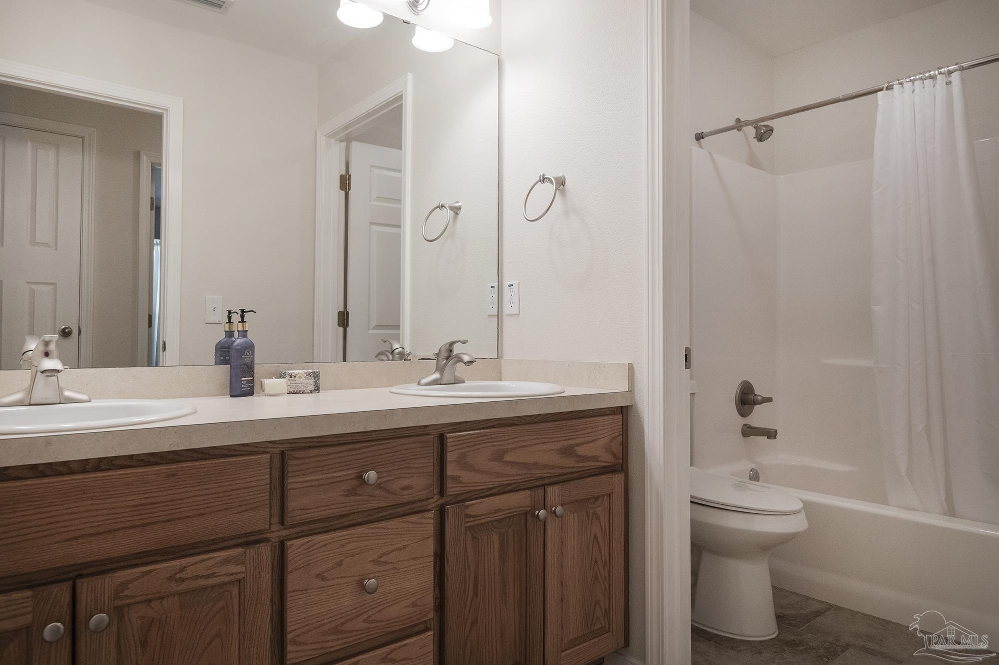 8501 Highway 97 Walnut Hill, FL 32568 - Photo 36 of 55 a bathroom with a double vanity sink toilet and a mirror