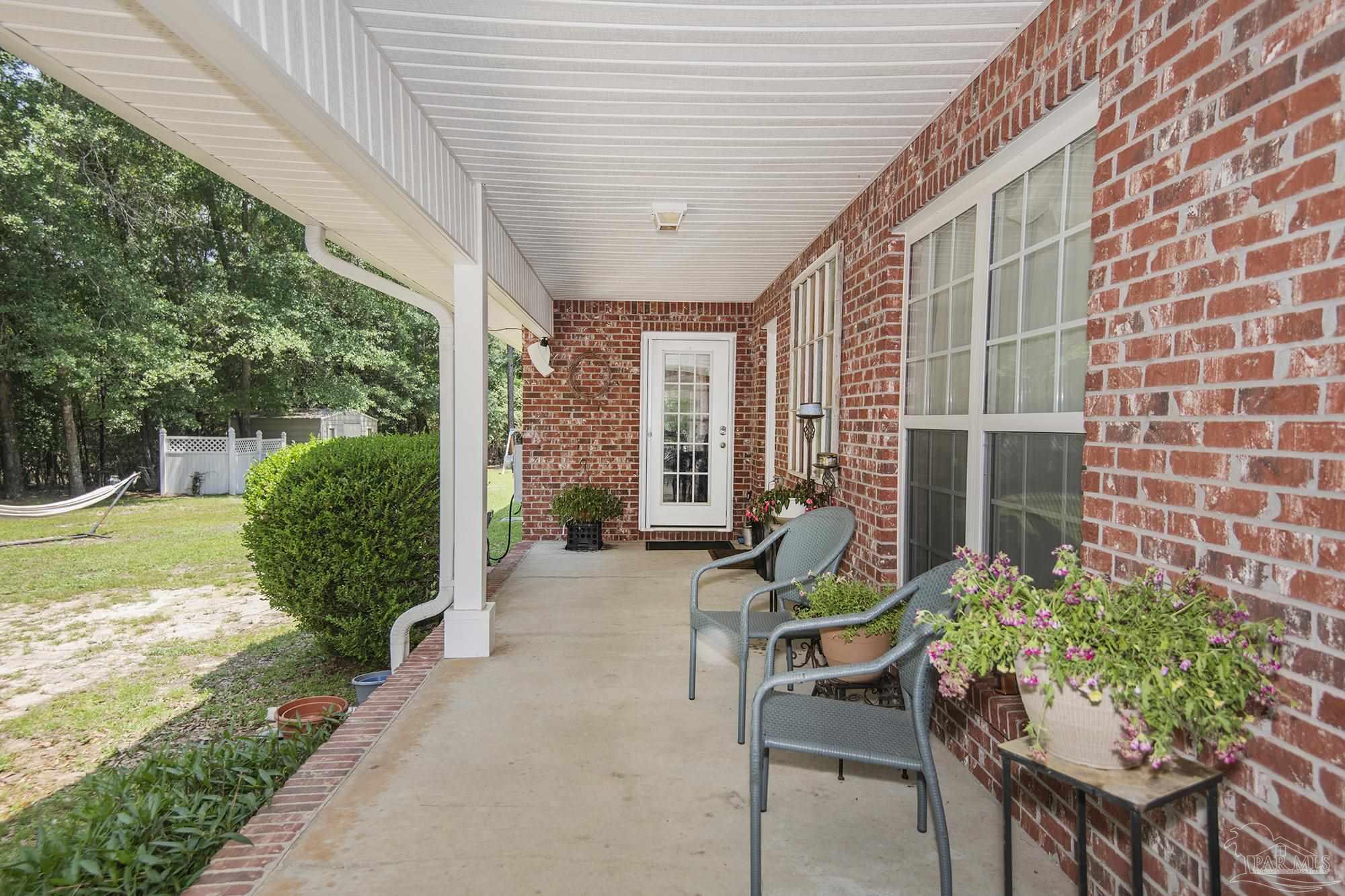 8501 Highway 97 Walnut Hill, FL 32568 - Photo 5 of 55 a building outdoor space with patio furniture and garden