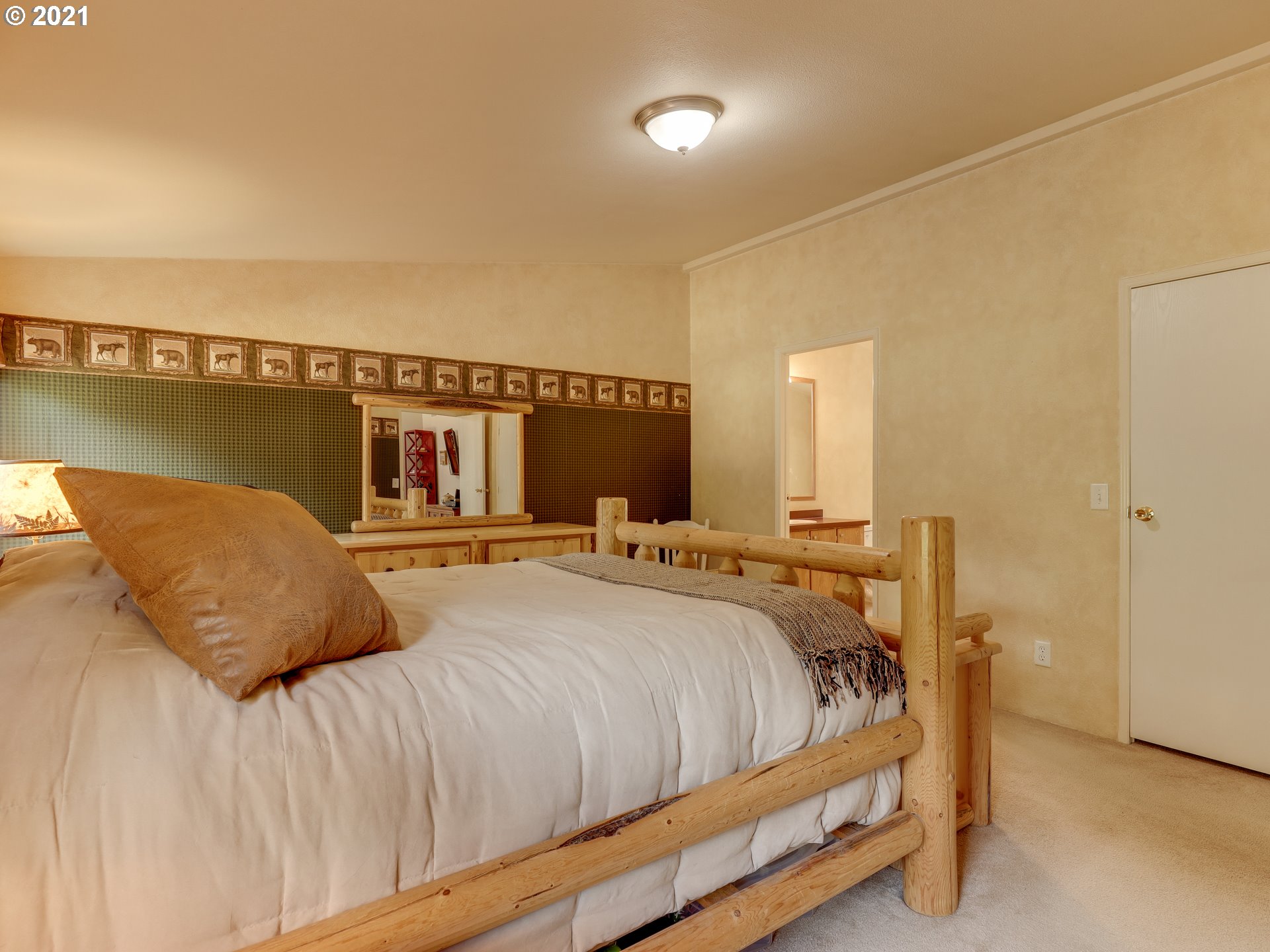 44644 Southeast Coalman Road Sandy, OR 97055 - Photo 13 of 31 a bedroom with a large bed and a chandelier