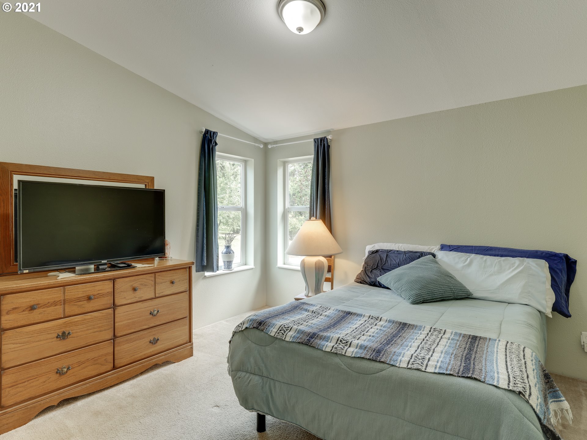 44644 Southeast Coalman Road Sandy, OR 97055 - Photo 17 of 31 a bedroom with a bed and a flat screen tv in it