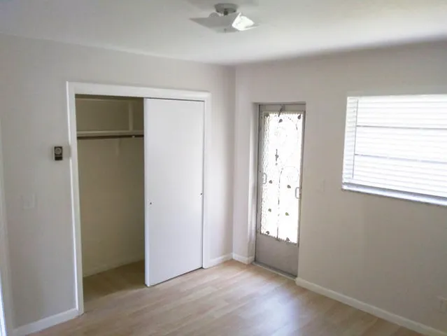an empty room with windows and closet