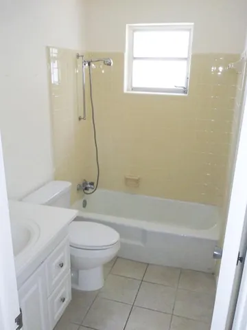 a bathroom with a granite countertop sink a toilet and a bathtub