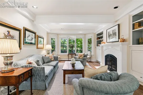 a living room with furniture fireplace and a large window