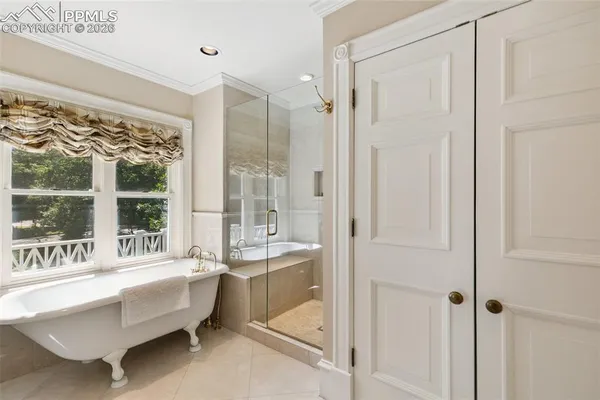 a spacious en suite bathroom with a tub shower and sink