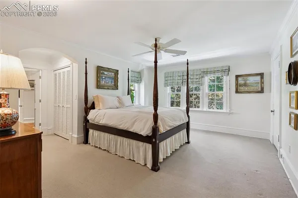 a bedroom with a large bed and a chandelier