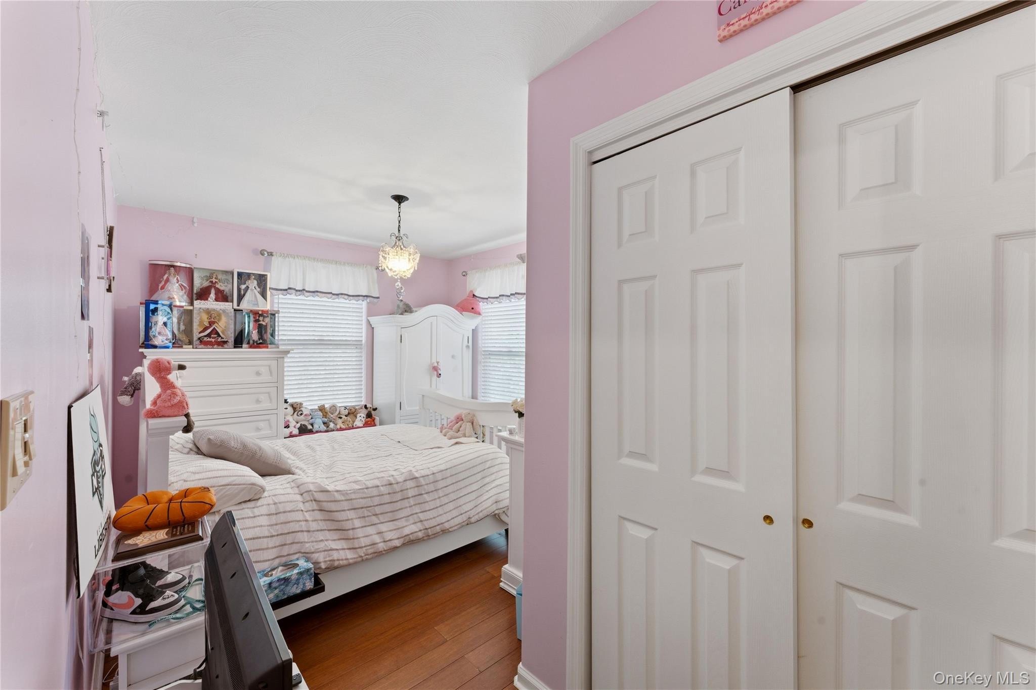 136 Meridian Boulevard Queens, NY 11692 - Photo 14 of 29 a bedroom with a bed and a chandelier