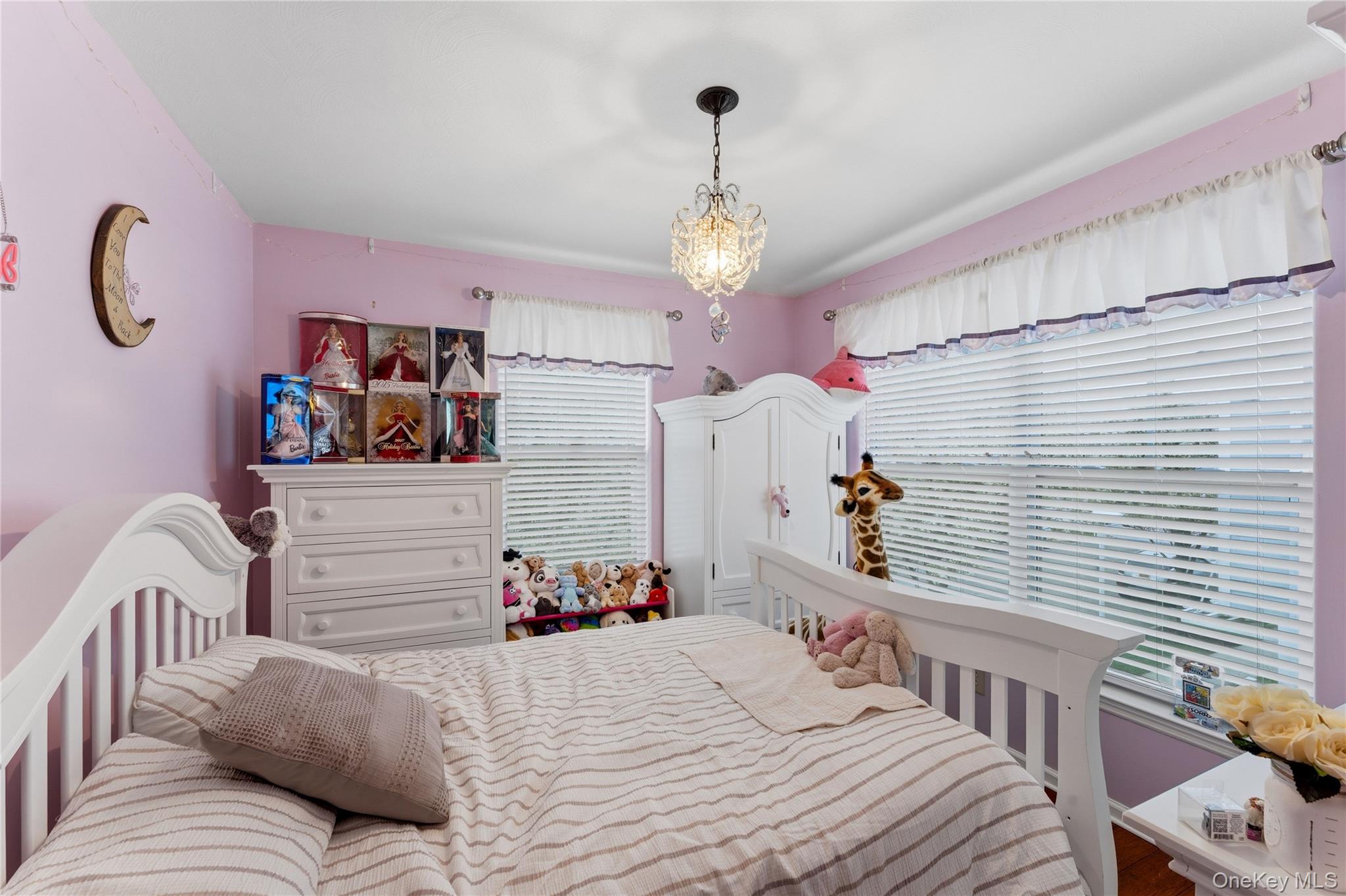 136 Meridian Boulevard Queens, NY 11692 - Photo 15 of 29 a bedroom with a bed and a chandelier