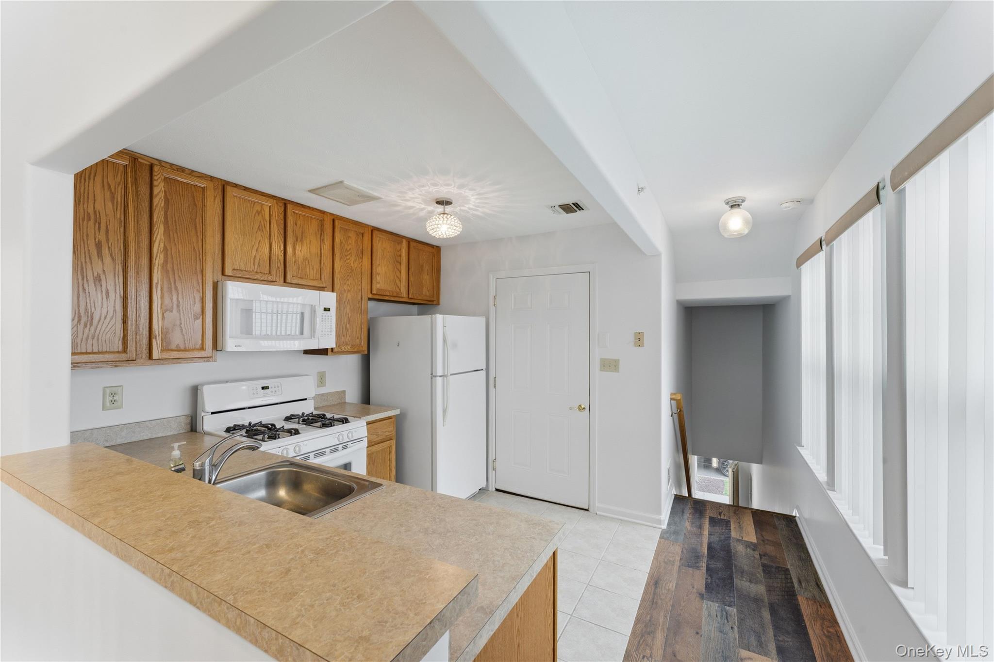 136 Meridian Boulevard Queens, NY 11692 - Photo 21 of 29 a kitchen with a refrigerator a stove a sink and a cabinets