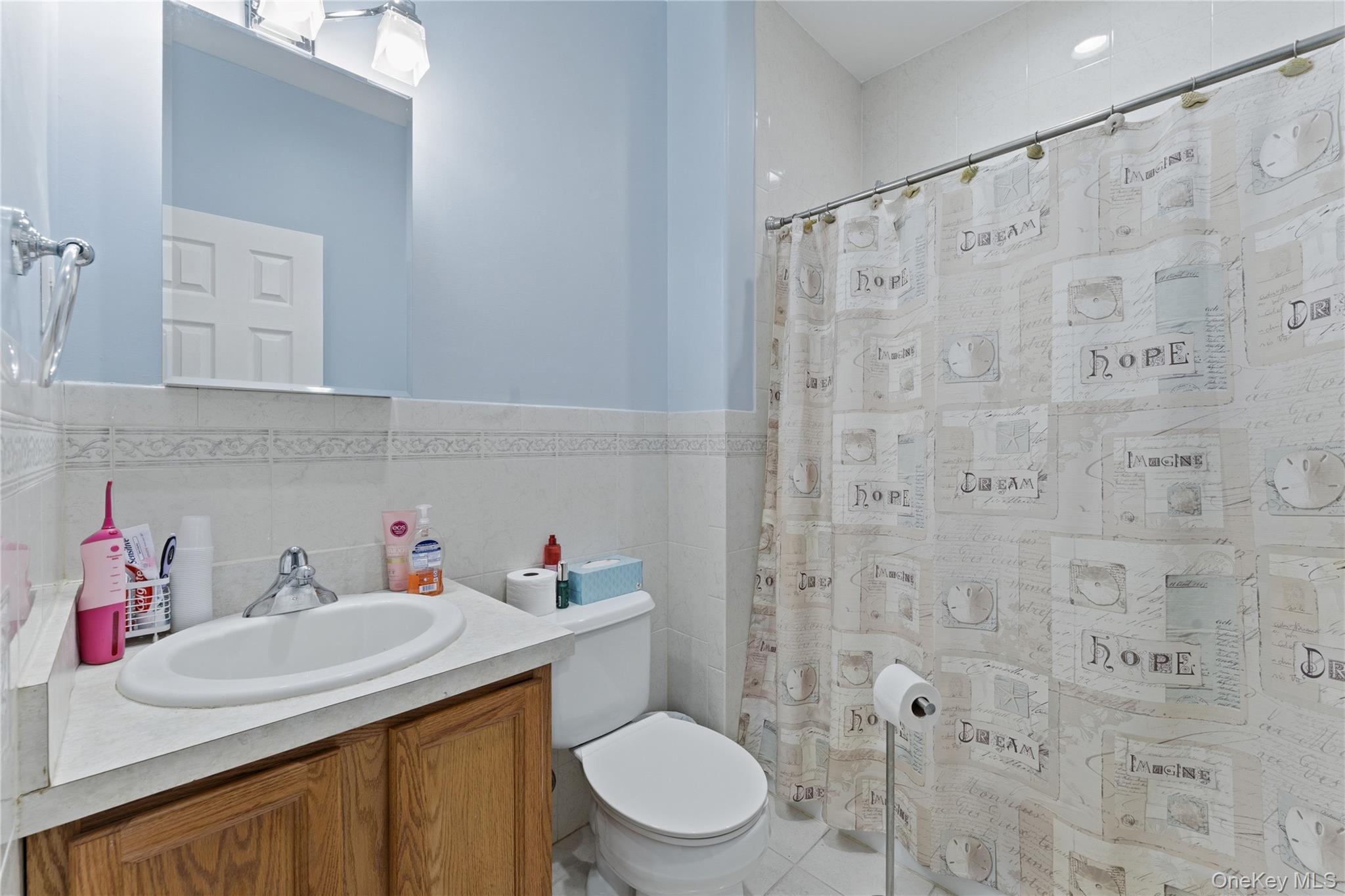 136 Meridian Boulevard Queens, NY 11692 - Photo 10 of 29 a bathroom with a sink a toilet and shower curtain