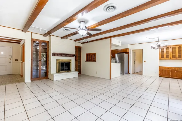 a view of an empty room with window and chandelier