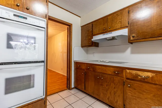 a view of an empty room and window with a chandelier fan