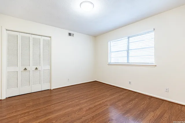 a view of an empty room with wooden floor