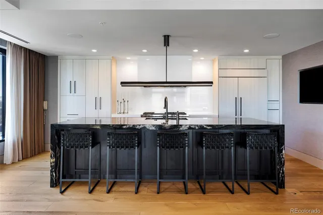 a kitchen with stainless steel appliances granite countertop a sink and a refrigerator