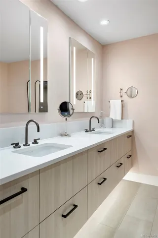 a bathroom with double sink and a mirror