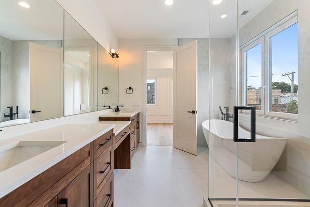 a spacious bathroom with a double vanity sink a large mirror and a bathtub