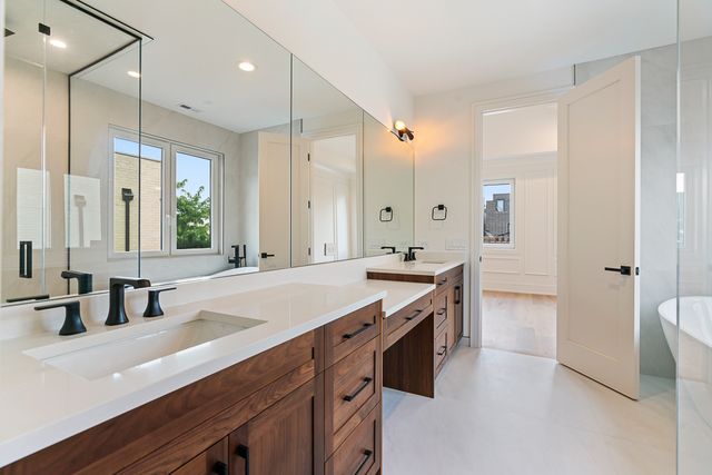 a spacious bathroom with a granite countertop sink a mirror and a bathtub