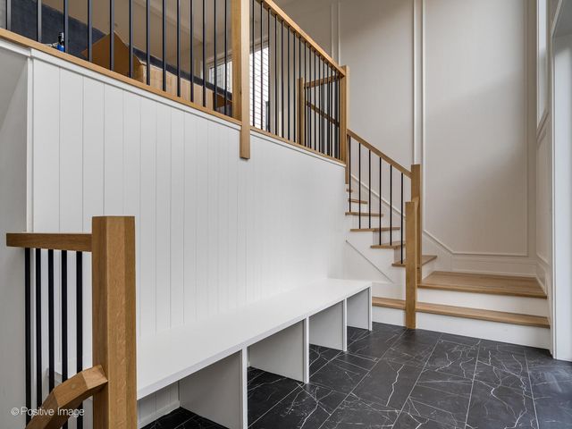 a view of staircase with lots of frames on wall and a window