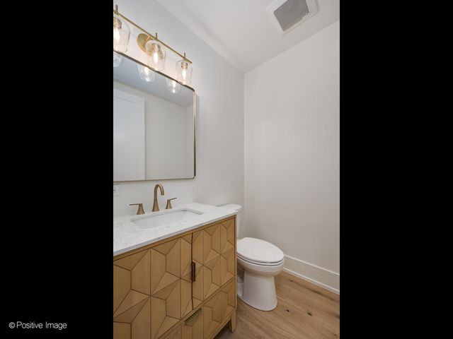 a bathroom with a granite countertop sink toilet and mirror