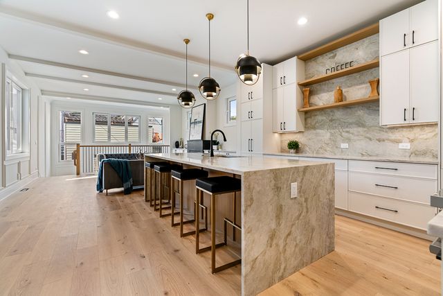 a kitchen with stainless steel appliances kitchen island granite countertop a sink and a refrigerator