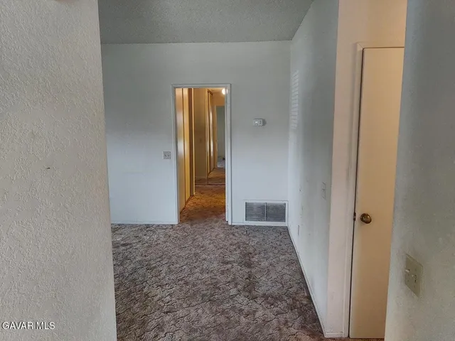 a bathroom with a granite countertop sink a toilet a mirror and window