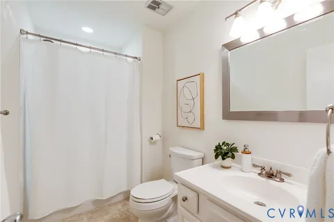 a bathroom with a sink vanity mirror and toilet