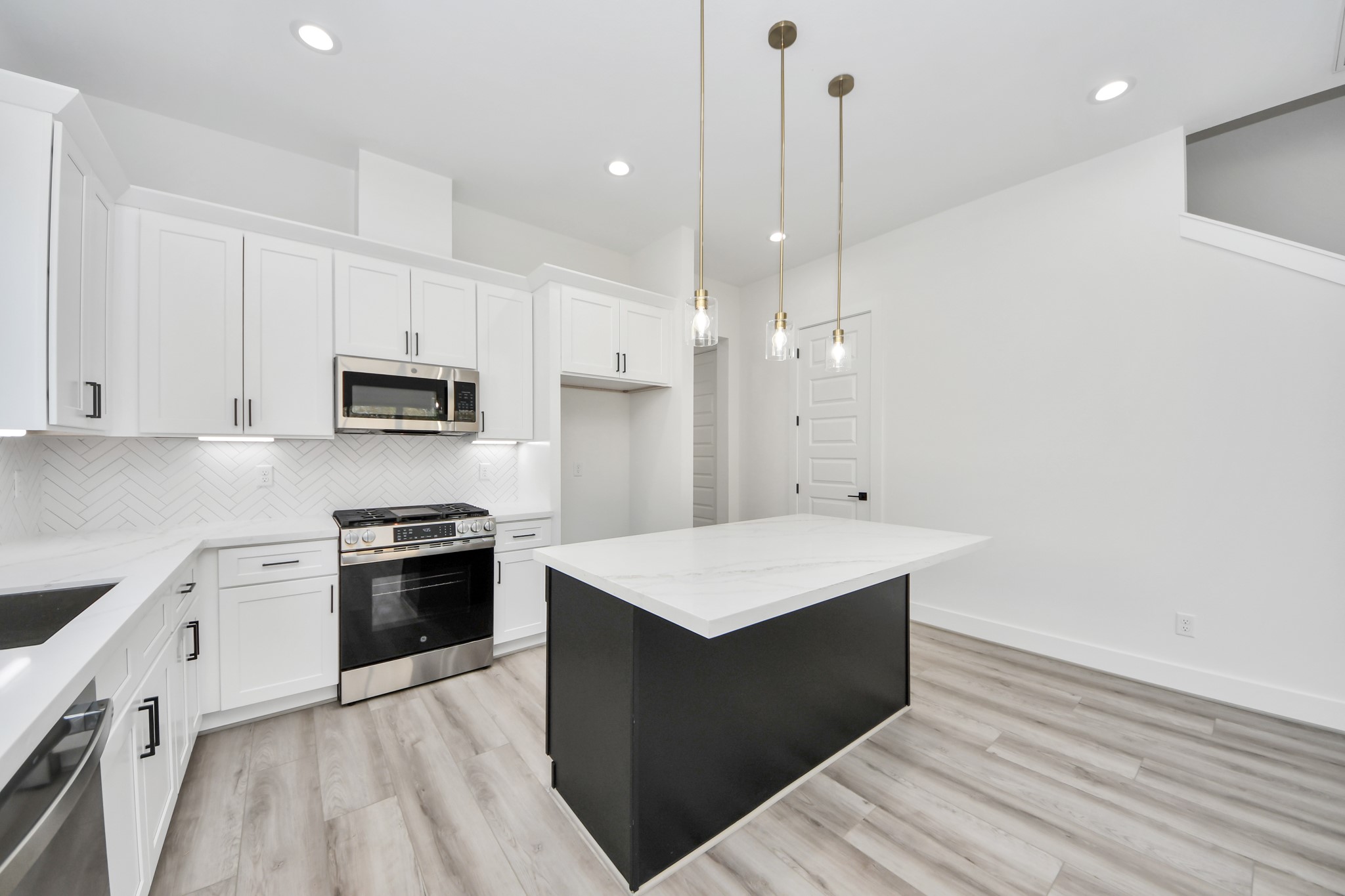7012 St Augustine Street Houston, TX 77021 - Photo 9 of 45 a kitchen with kitchen island a sink dishwasher stove and white cabinets with wooden floor