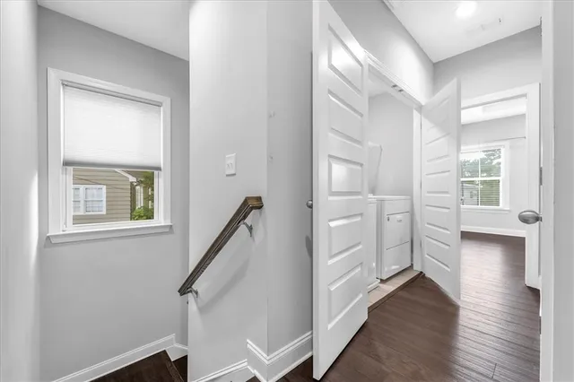 an empty room with wooden floor ceiling fan and windows