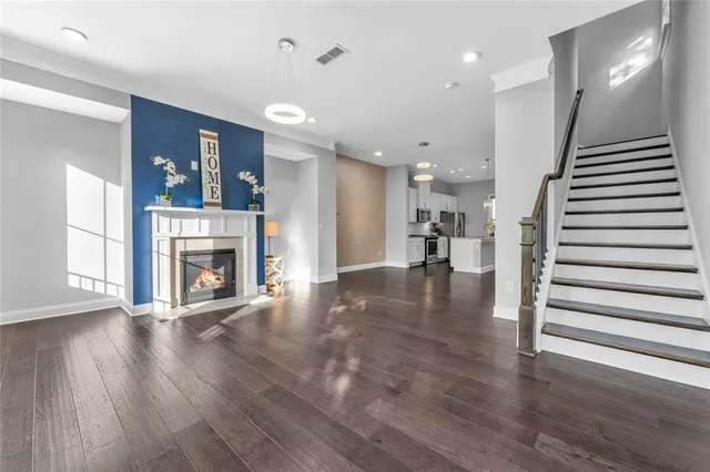 an empty room with wooden floor ceiling fan and windows