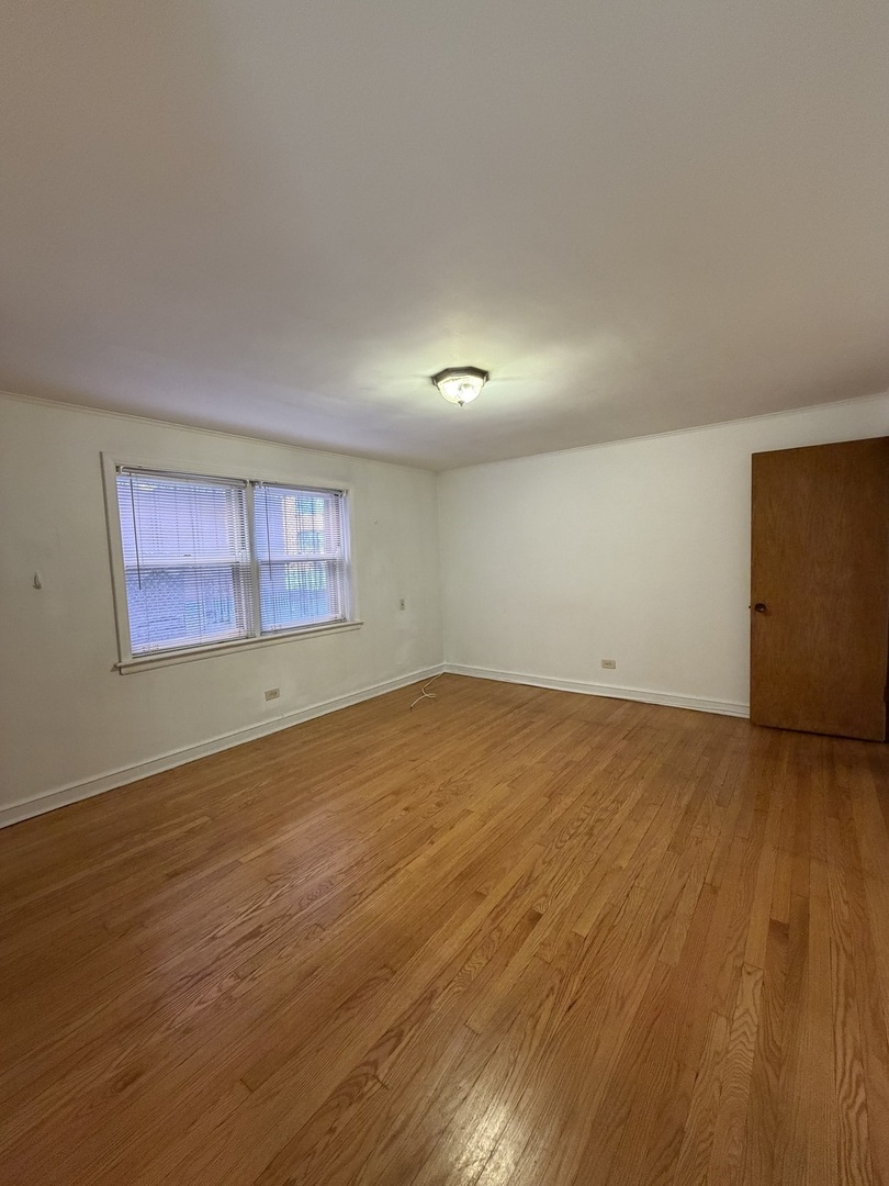 7228 South Phillips Avenue, Unit G Chicago, IL 60649 - Photo 3 of 10 a view of empty room with wooden floor and fan