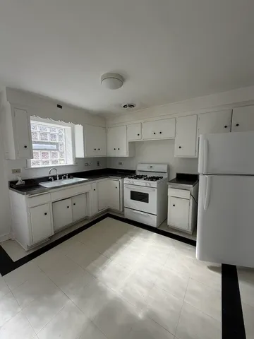 a large kitchen with cabinets white stainless steel appliances and a refrigerator