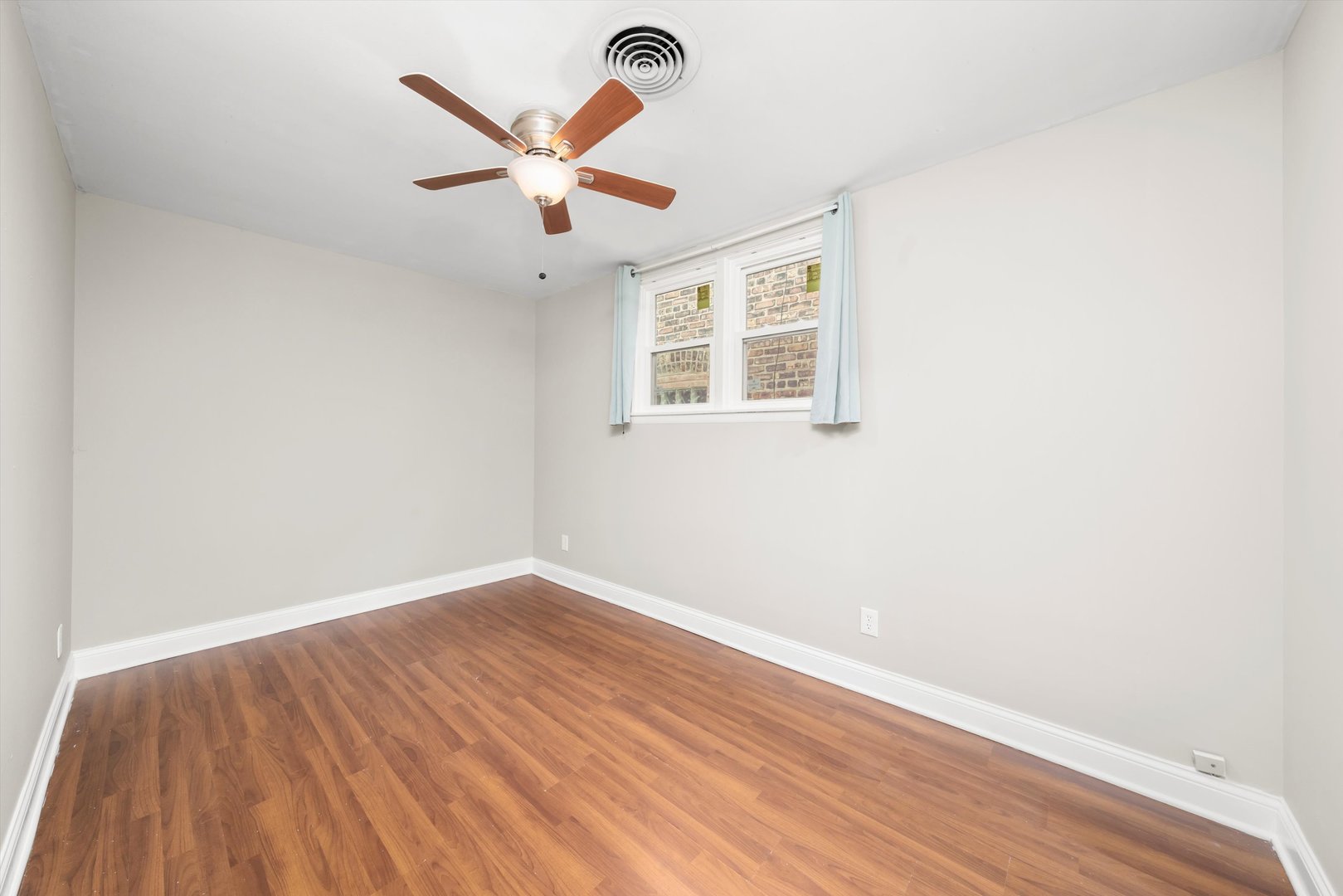 2420 South Oakley Avenue, Unit 2 Chicago, IL 60608 - Photo 8 of 15 an empty room with wooden floor and ceiling fan