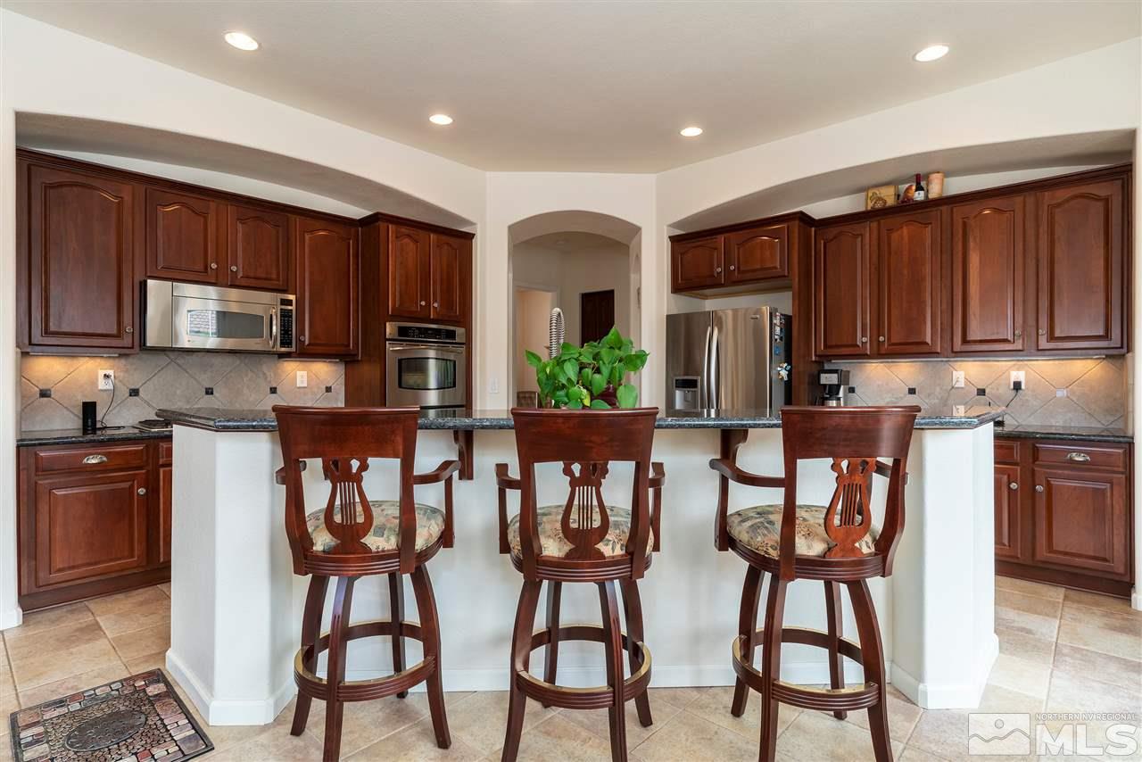 2645 Trail Rider Drive Reno, NV 89521 - Photo 18 of 25 a kitchen with stainless steel appliances kitchen island granite countertop a refrigerator and microwave