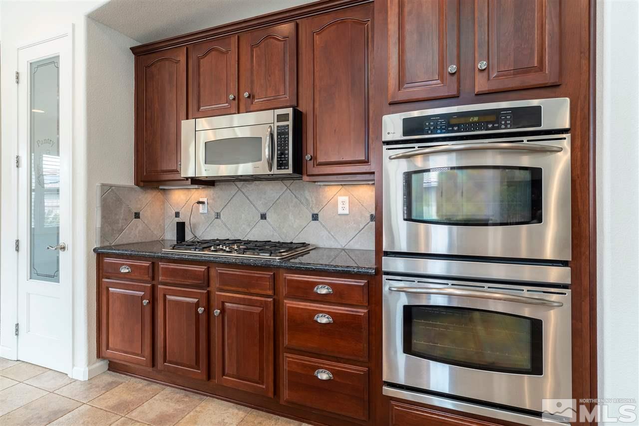 2645 Trail Rider Drive Reno, NV 89521 - Photo 19 of 25 a kitchen with granite countertop cabinets stainless steel appliances and wooden floor