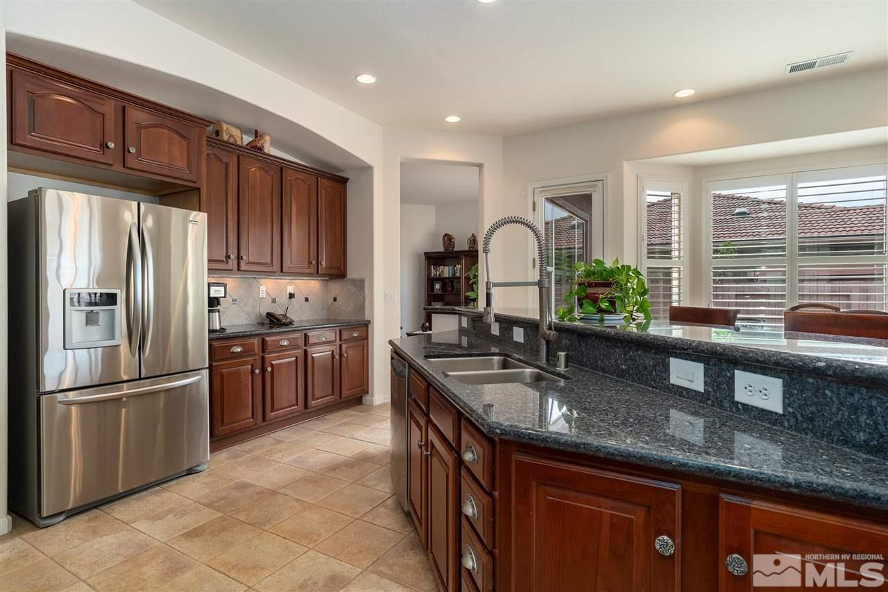 2645 Trail Rider Drive Reno, NV 89521 - Photo 20 of 25 a kitchen with granite countertop a refrigerator and wooden cabinets