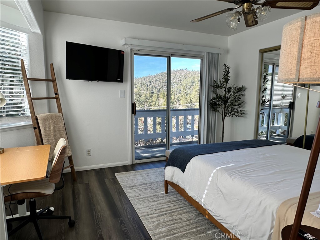 33010 Donner Lane Running Springs, CA 92382 - Photo 11 of 29 a bedroom with a bed a flat screen tv and a large window