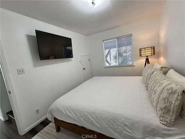 a bedroom with a large bed and a flat screen tv