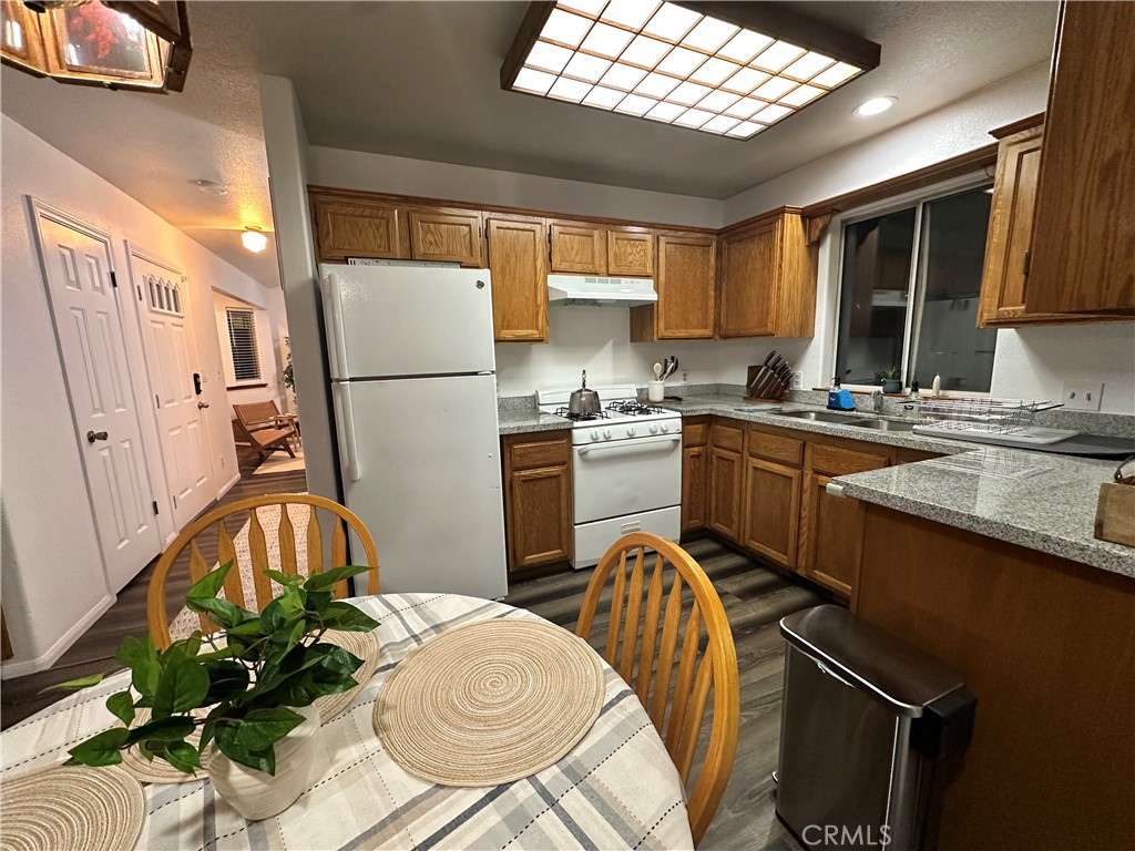 33010 Donner Lane Running Springs, CA 92382 - Photo 23 of 29 a kitchen with stainless steel appliances granite countertop a sink a stove a refrigerator with grey cabinets and wooden floor