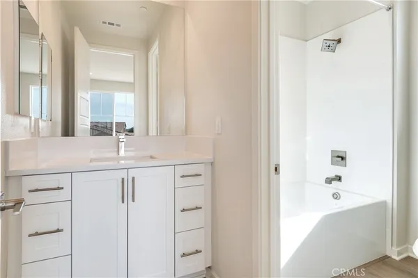 a hallway with white cabinets and wooden floor