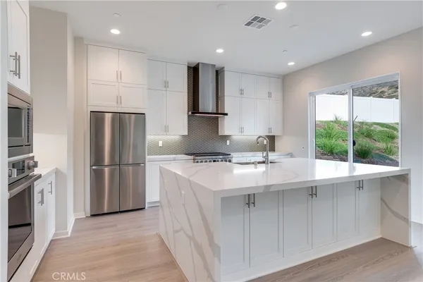 a kitchen with kitchen island a sink stainless steel appliances and cabinets