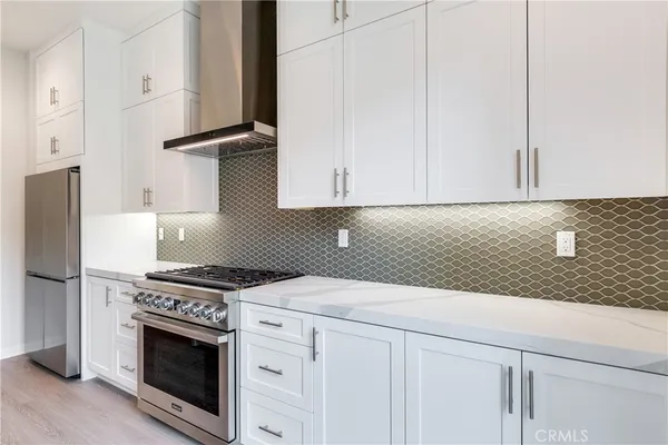 a kitchen with granite countertop white cabinets and stainless steel appliances