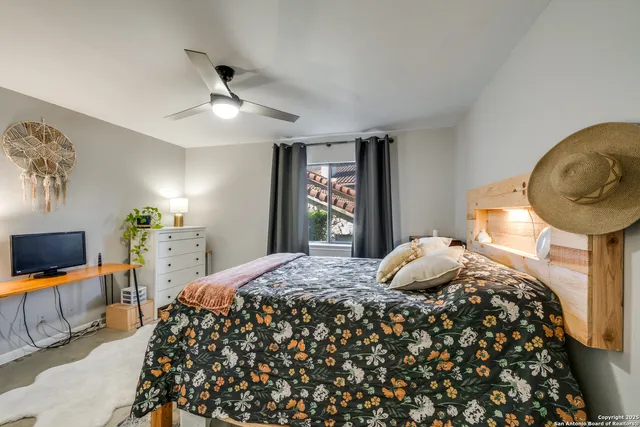 a bedroom with a bed and a flat tv screen on dresser