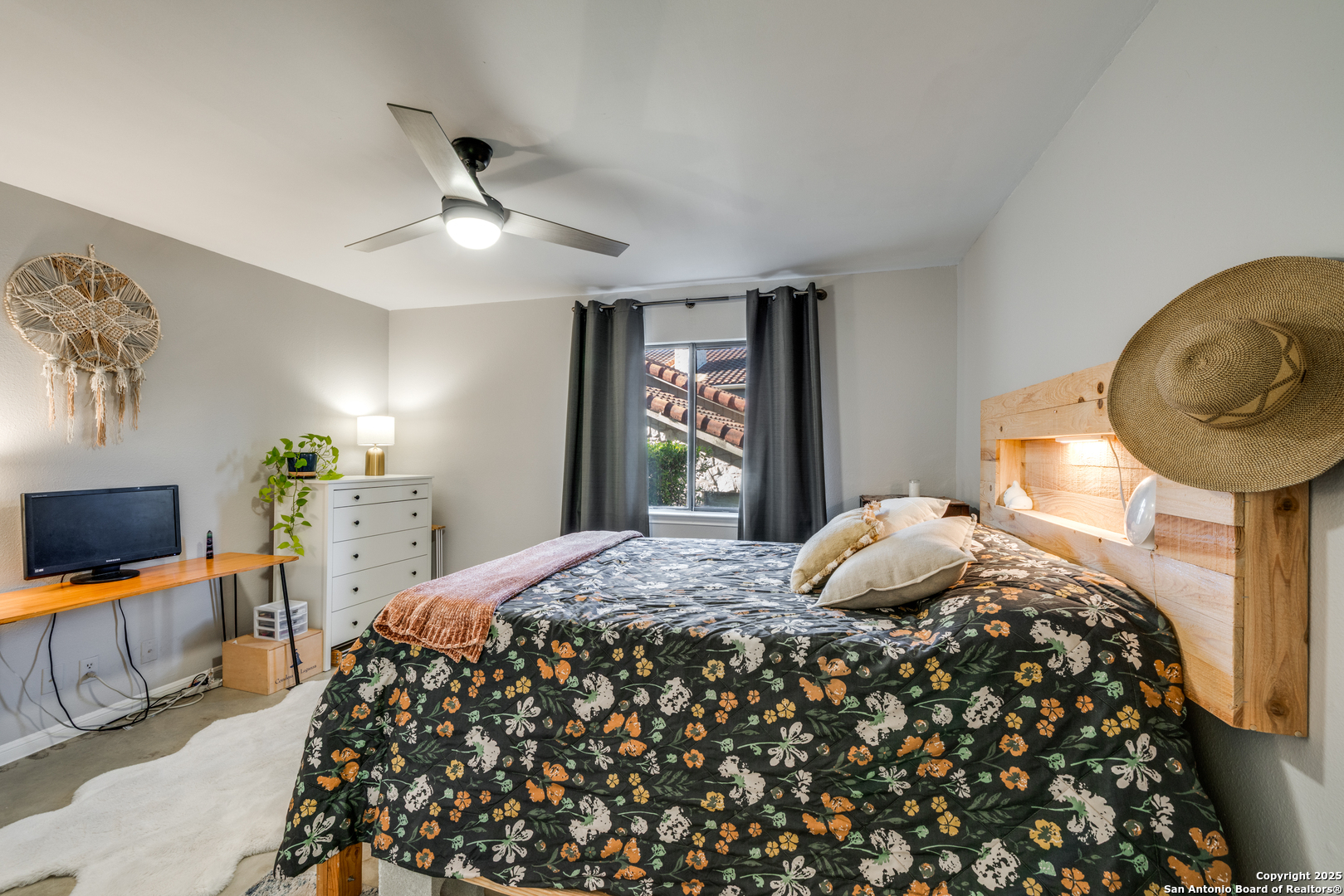 7738 Chambers Road, Unit 903 San Antonio, TX 78229 - Photo 12 of 22 a bedroom with a bed and a flat tv screen on dresser