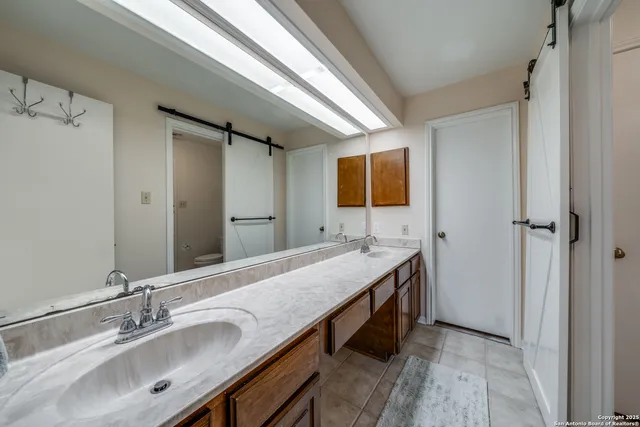 a bathroom with a granite countertop sink a mirror and a bathtub