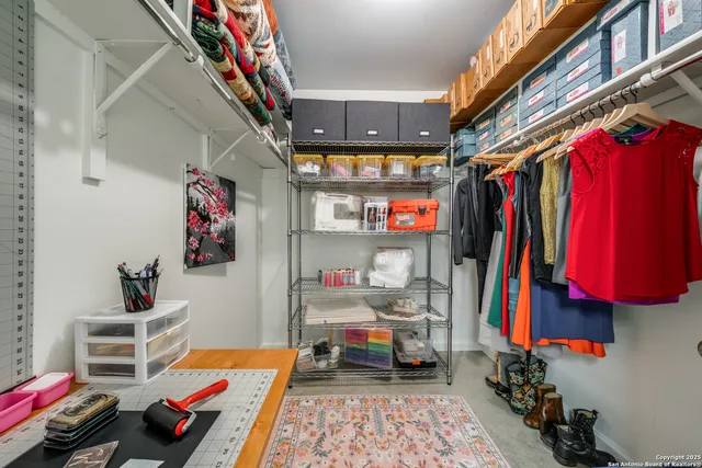 a view of walk in closet with clothes and shoes