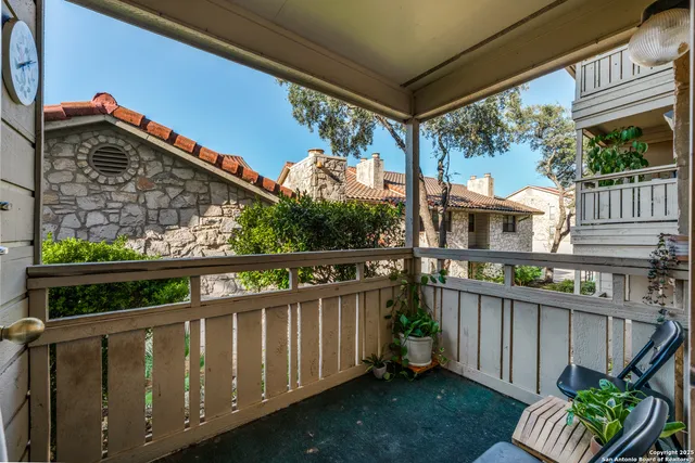 a view of a patio with table and chairs potted plants and large tree