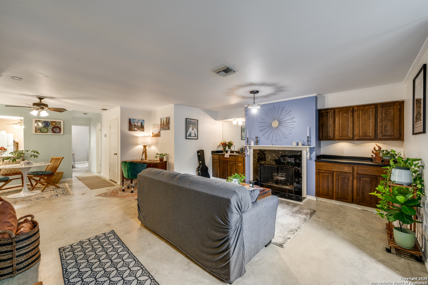 7738 Chambers Road, Unit 903 San Antonio, TX 78229 - Photo 2 of 22 a living room with furniture a fireplace and a dining table with kitchen view